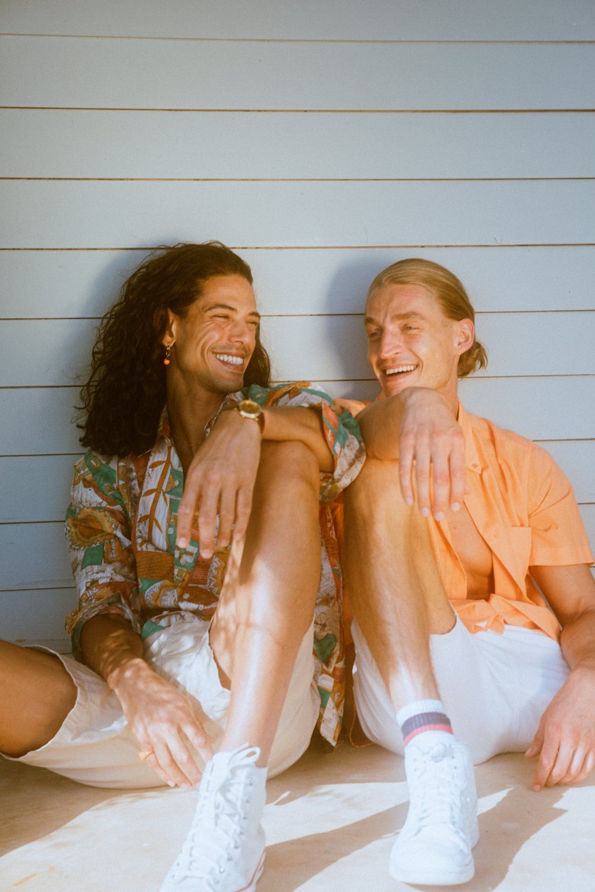 two individuals sitting on a porch, smiling and laughing